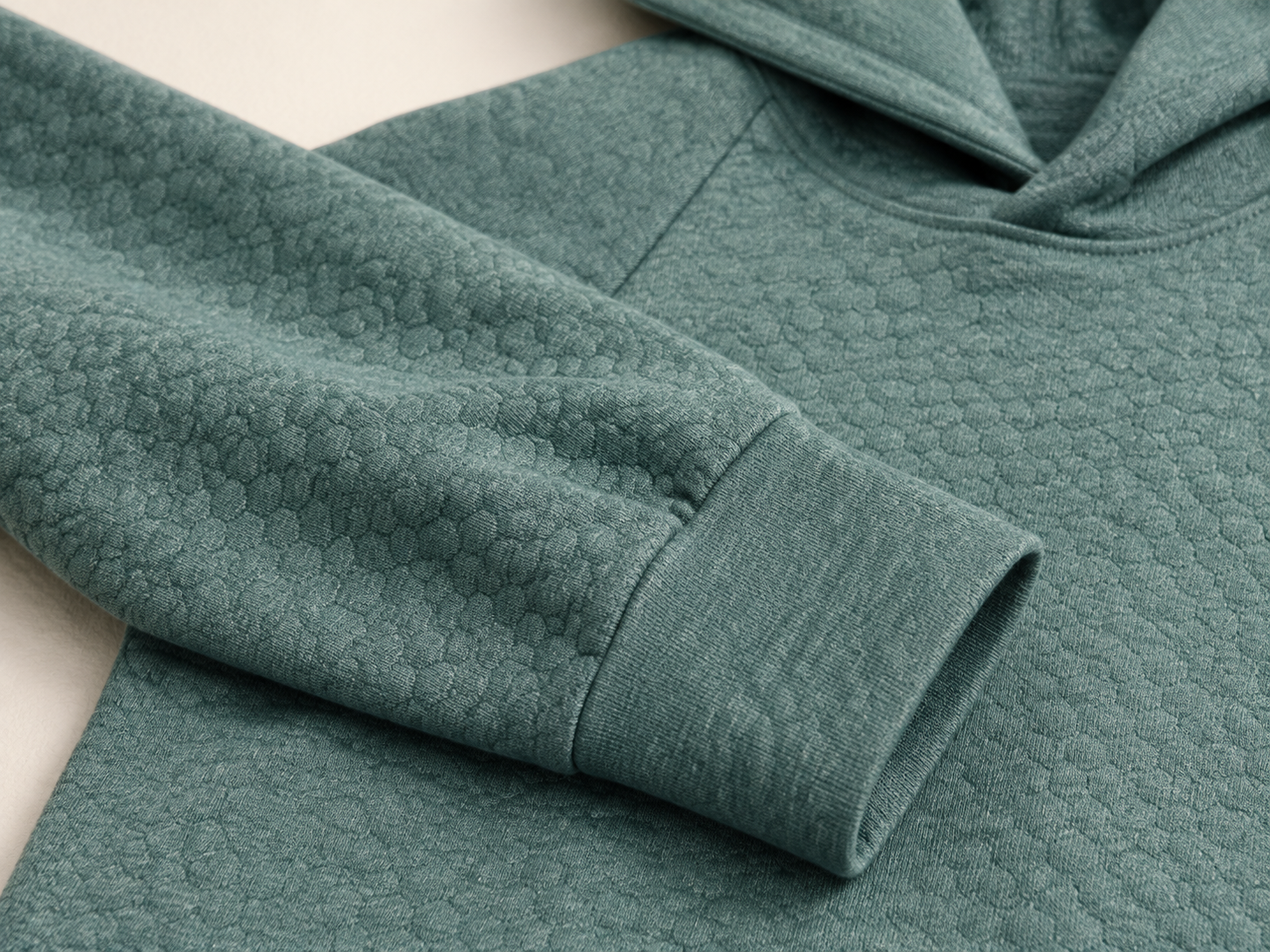 Editorial illustration of a folded Ellison sleeve and banded cuff, emphasizing the heathered green honeycomb pattern